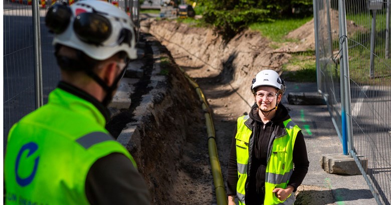 Kaukolämmön työmaalla näkyy kaukolämpöputki sekä kaksi Oulun Energian työntekijää.