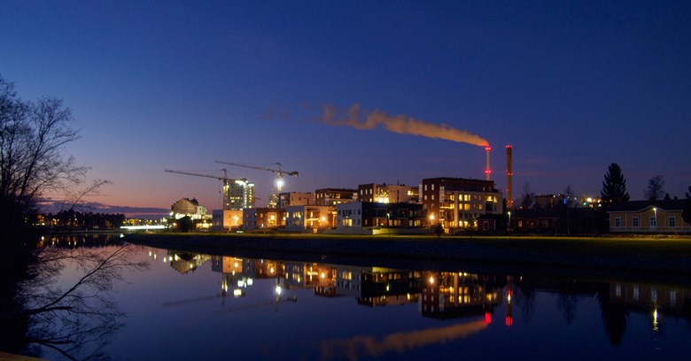 Kuva Toppilansalmesta Oulusta illan hämärässä valaistuksessa. Taustalla näkyy Toppilan voimalaitoksen piiput. 